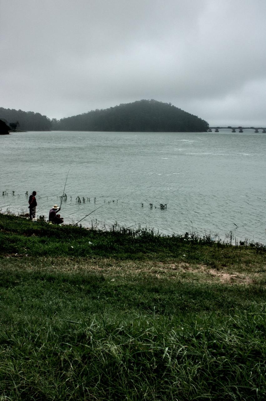 Homens pescando na orla do braço Bororé da Represa Billings