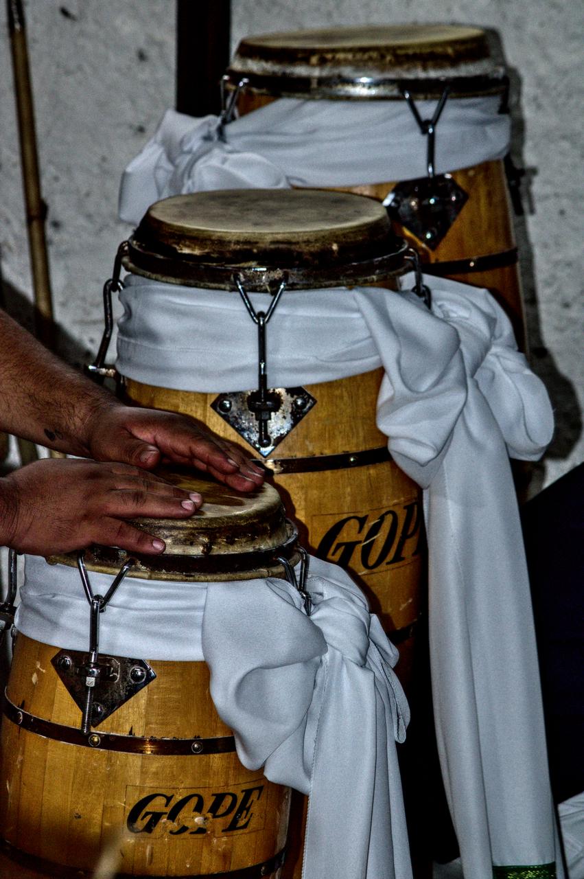 Homem descansa as faces sobre instrumentos tradicionais.