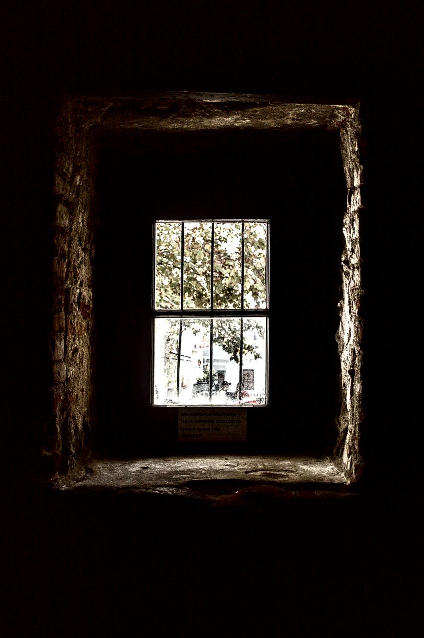 Janela de pedras de igreja antiga, luz e sombra.