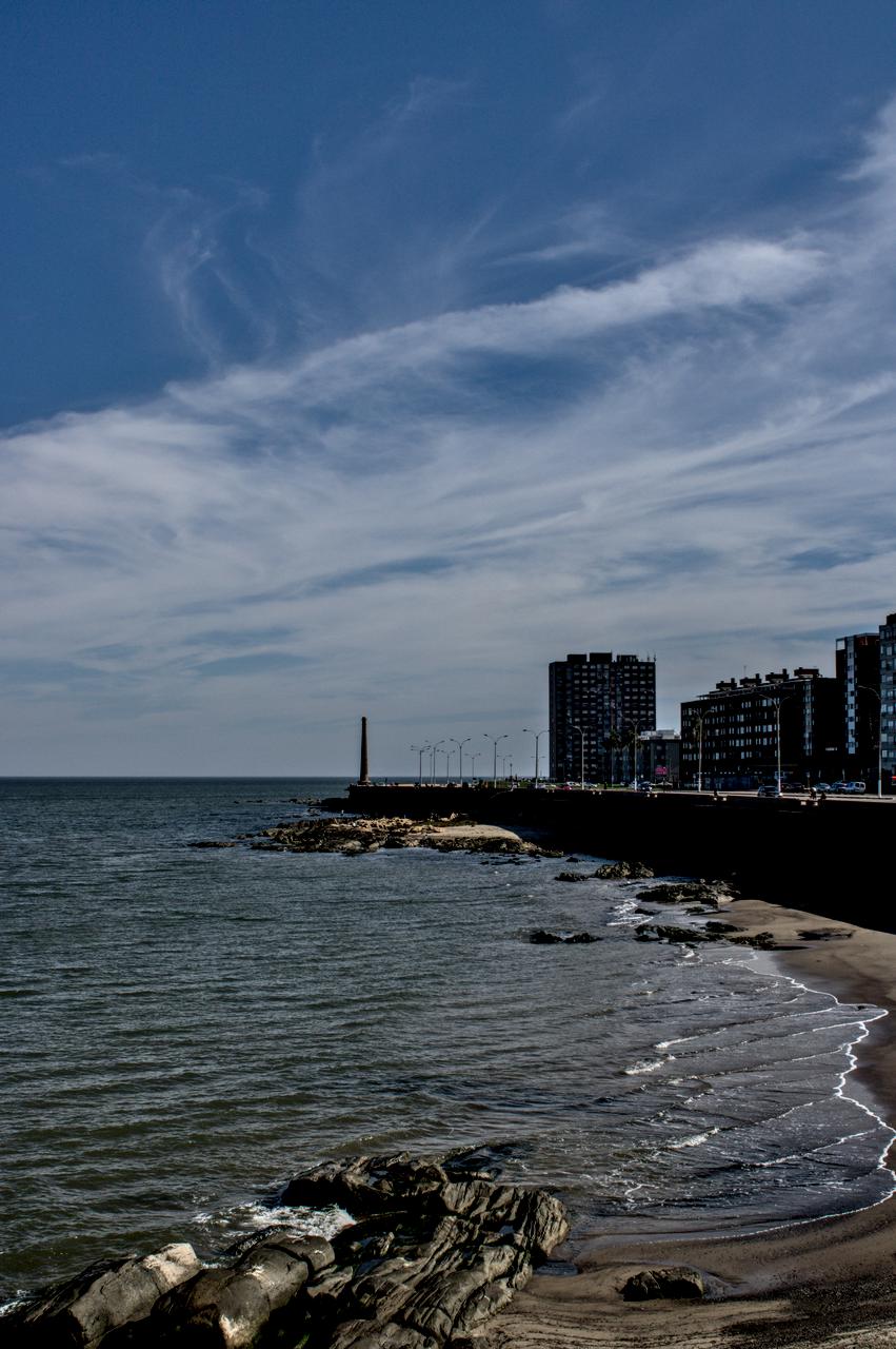 Chaminé e edifícios à beira-mar.