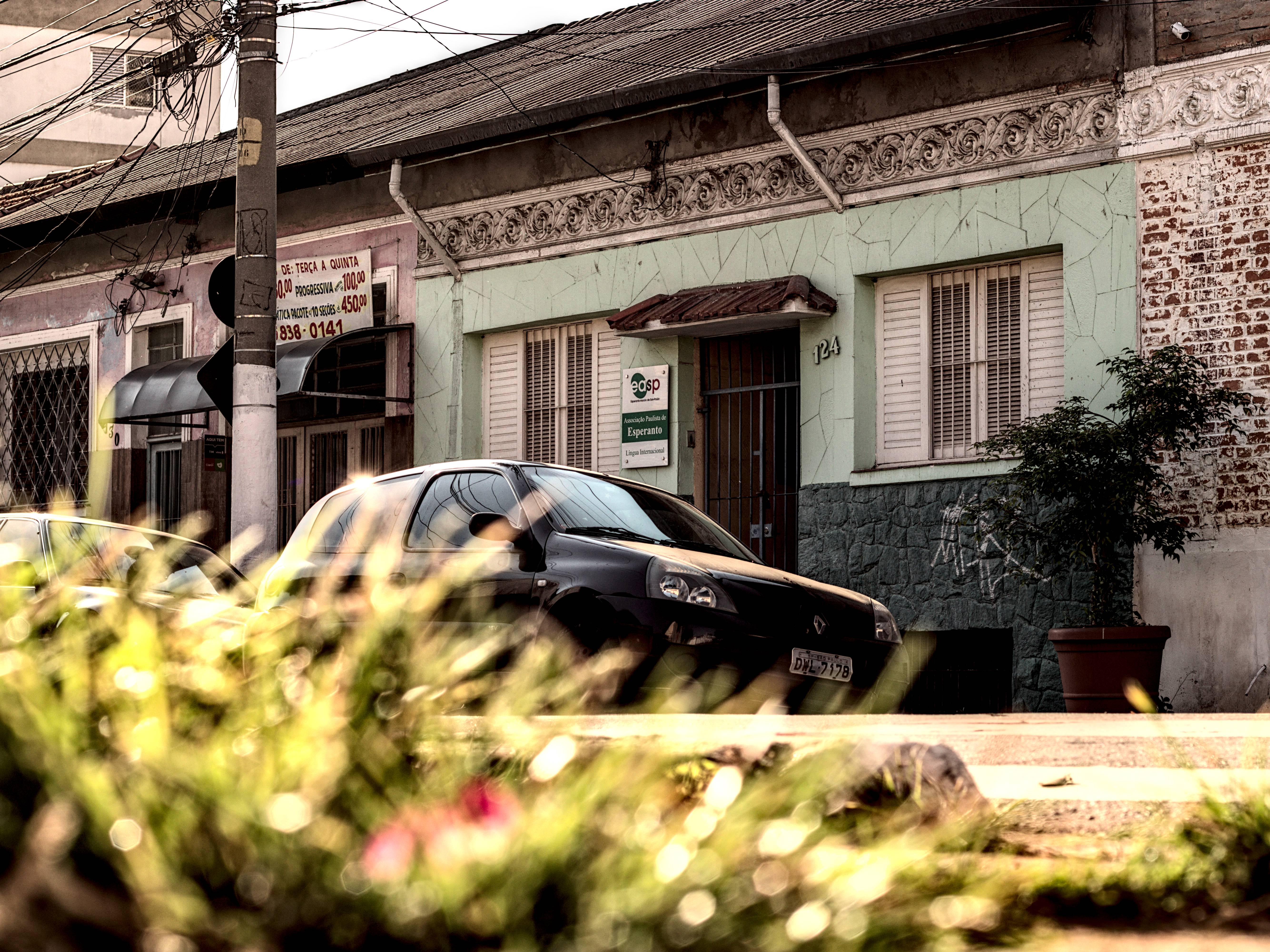 Construção verde atrás de relva desfocada. Placa indica Associação Paulista de Esperanto.